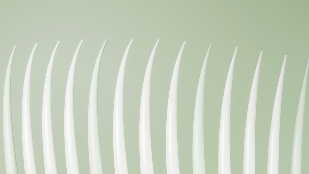 Row of white plastic forks arranged on a light green background in an organized, clean layout.