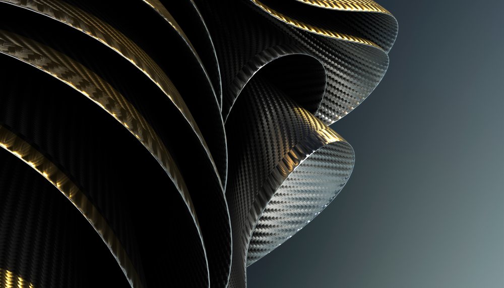Curved carbon fiber tubes with glossy black and gold highlights against a dark background in a detailed close-up view.