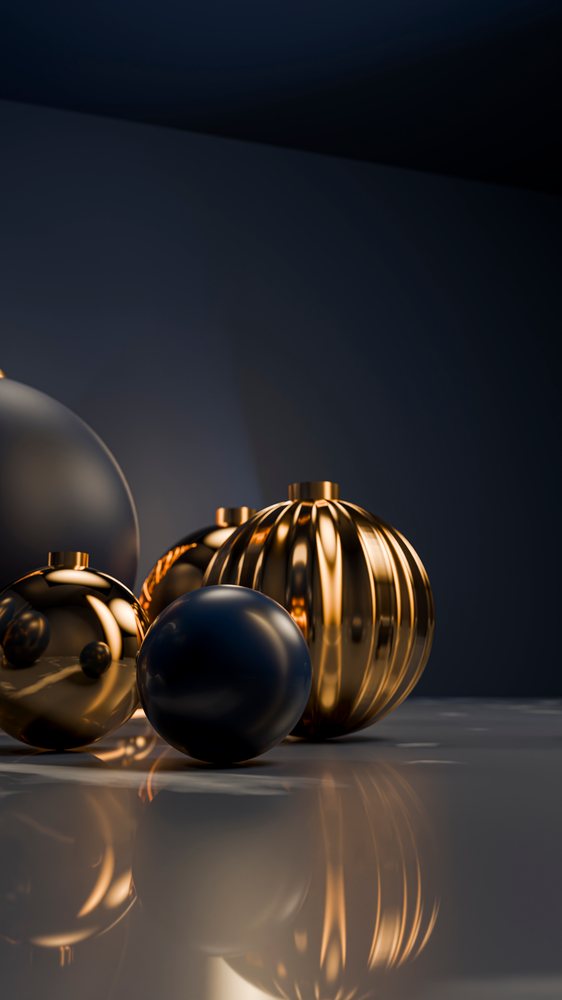 Gold and black reflective Christmas ornaments arranged on a glossy surface for a festive holiday display.