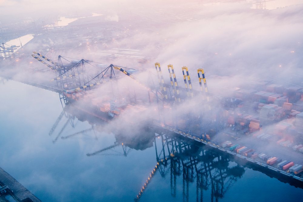 Cargo cranes and shipping containers at a container terminal on a foggy morning at the, Port of Long Beach, CA, USA.