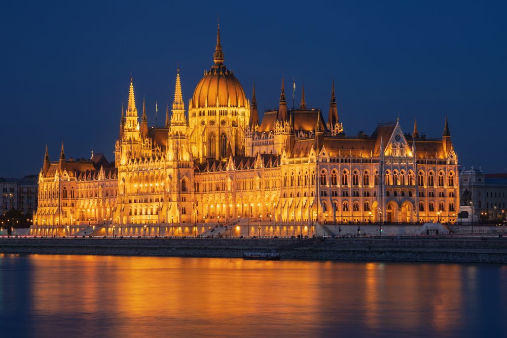 Hungarian Houses of Parliament illuminated at Dusk along the Danube River, Budapest, Hungary.