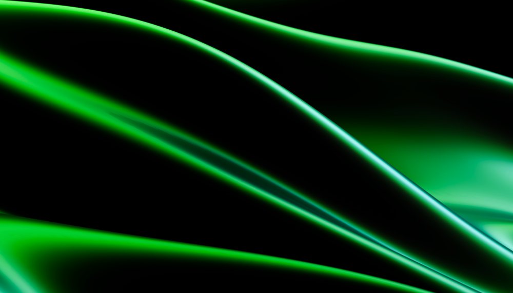 Green shiny silk fabric exhibiting smooth folds and a luxurious texture.