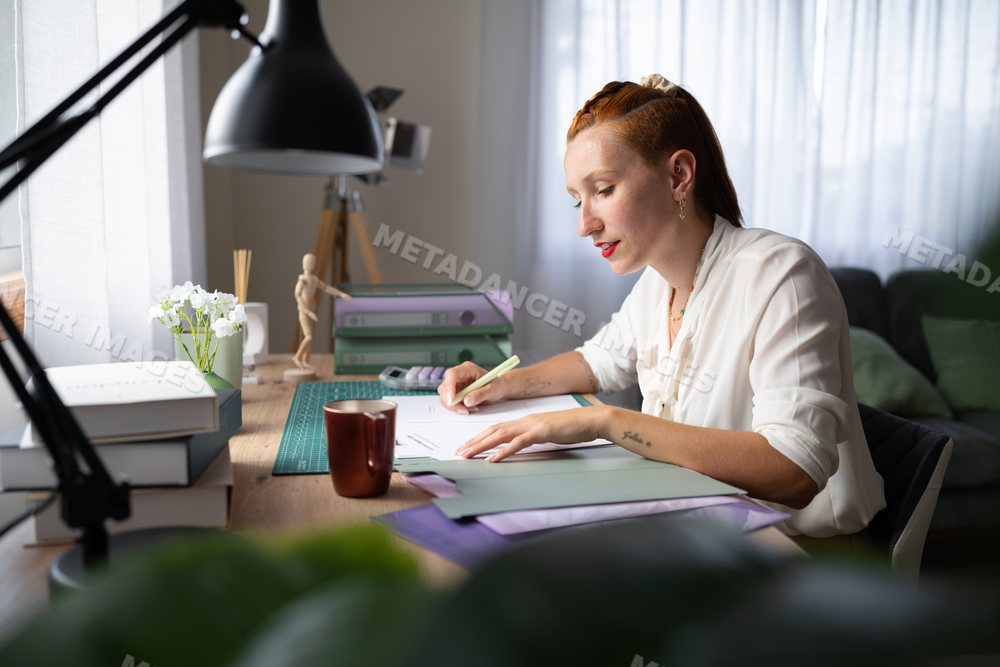 A white woman working from home writing at a desk in Galicia, spain