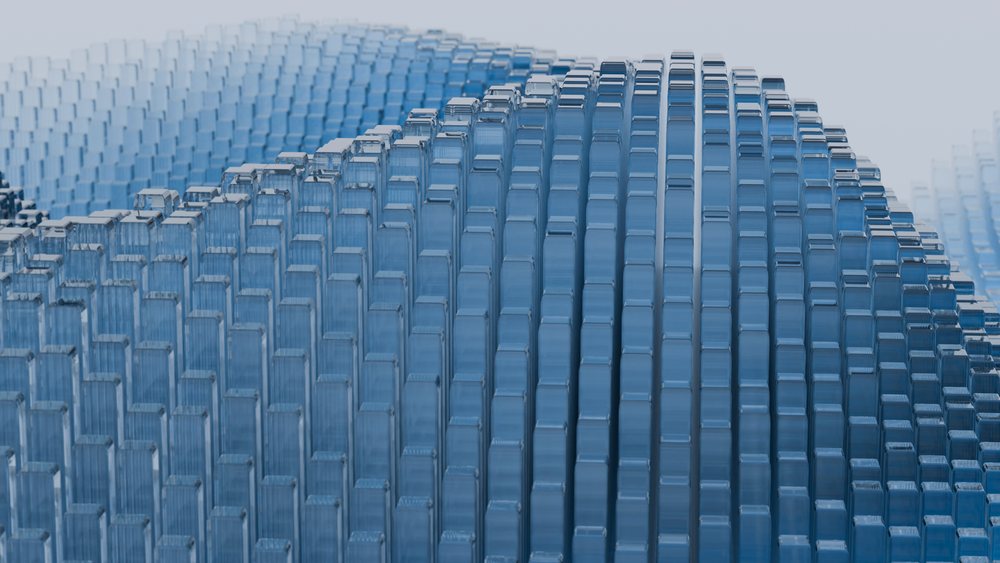 Transparent blue glass blocks are arranged in layered, stacked rows forming a curved wave pattern with visible reflections and refractions.