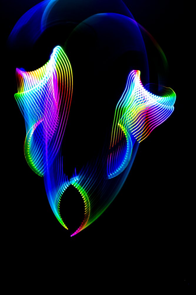 Colorful abstract light painting with vibrant LED ribbons and bright multicolor light trails on a dark background.