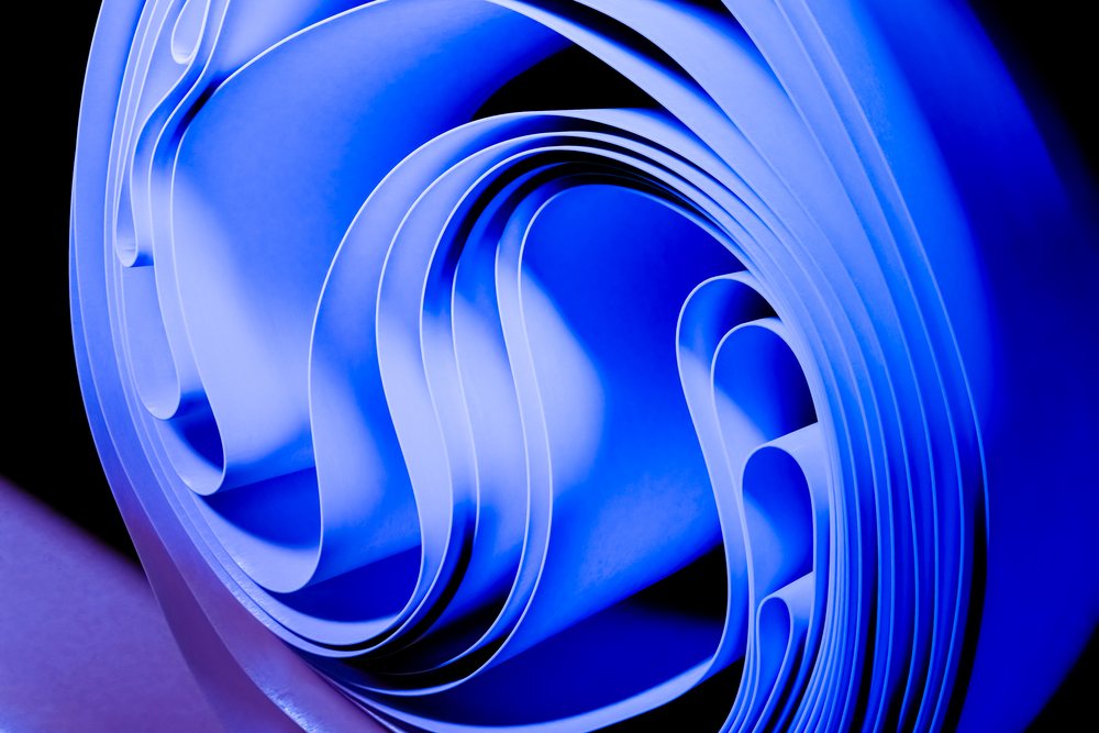 Abstract rendering of blue paper rolled and layered to form curved shapes and patterns.