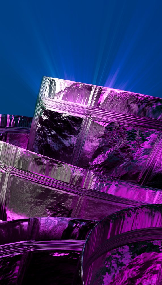 Stacked glass blocks illuminated with purple light against a blue background showing reflective and textured surfaces.