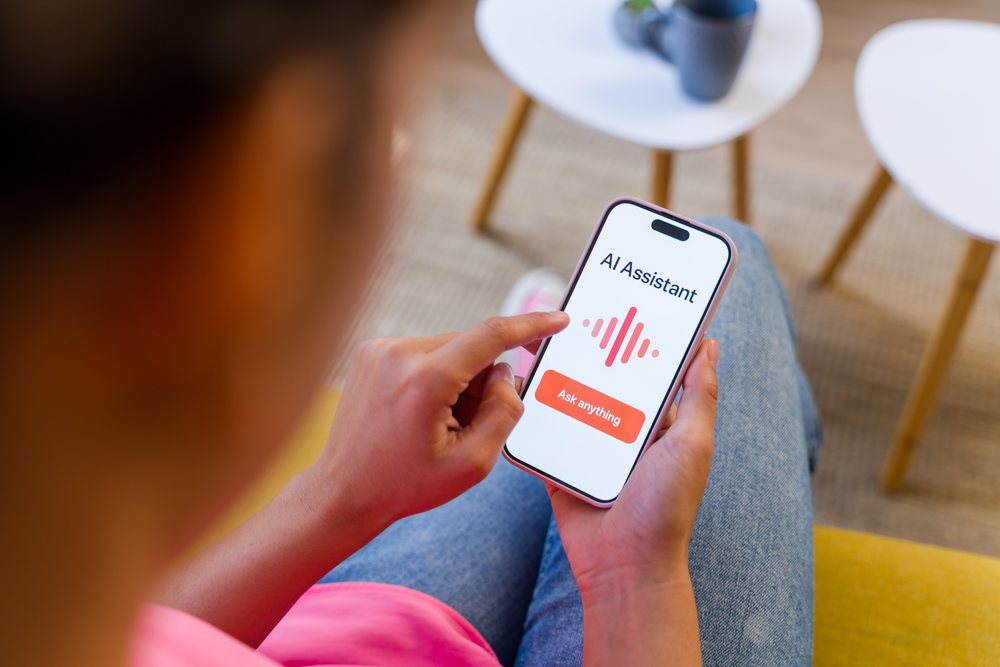 A person in a casual setting interacts with an AI assistant on a smartphone, Spain.