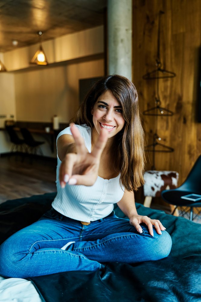 A smiling woman sitting on a bed