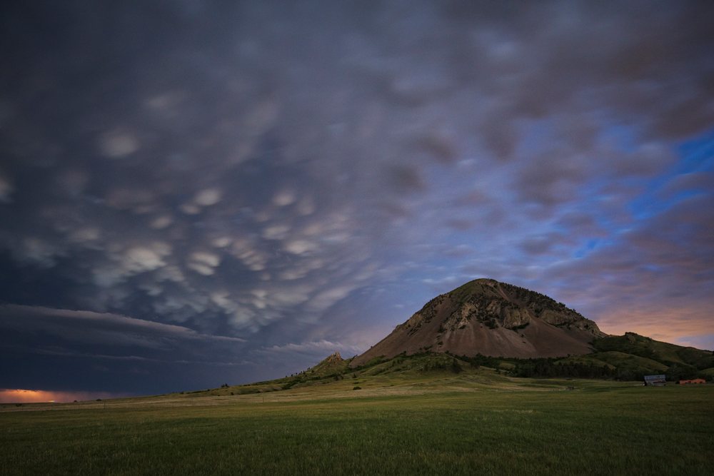 Receding Storm clouds move past bear Butte mountain over grassland, United States, Storm Chasing, Weather, Environmental Issues, Sturgis, South Dakota.