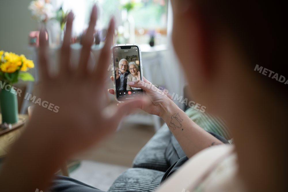 White Person video calling an older couple from home in Galicia