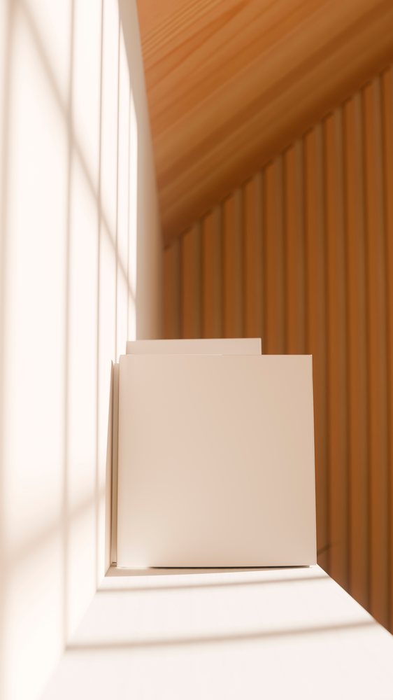 Stack of blank books illuminated by sunlight on a white shelf against a wood-paneled wall.