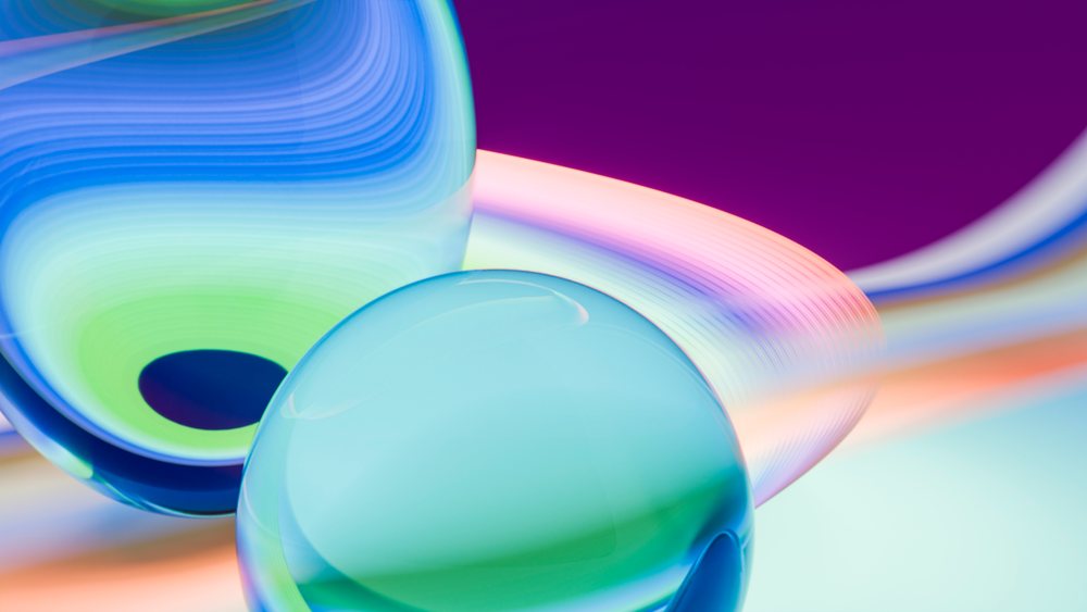 Colorful abstract digital artwork featuring glossy reflective glass spheres with vibrant gradients and curved light patterns.