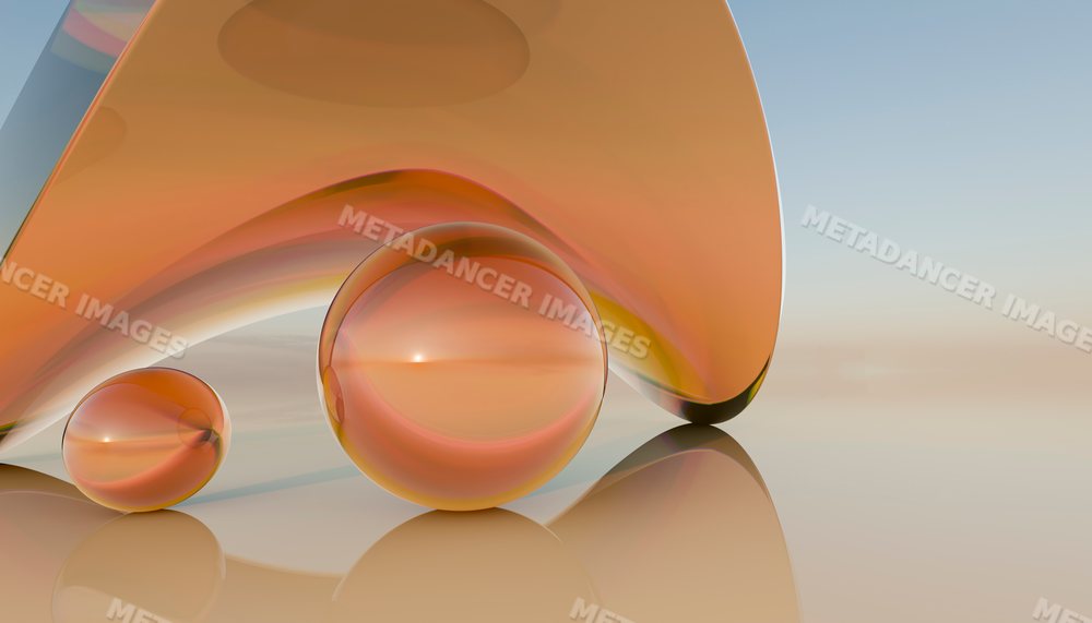 Two orange glass spheres next to a curved glass shape on a reflective