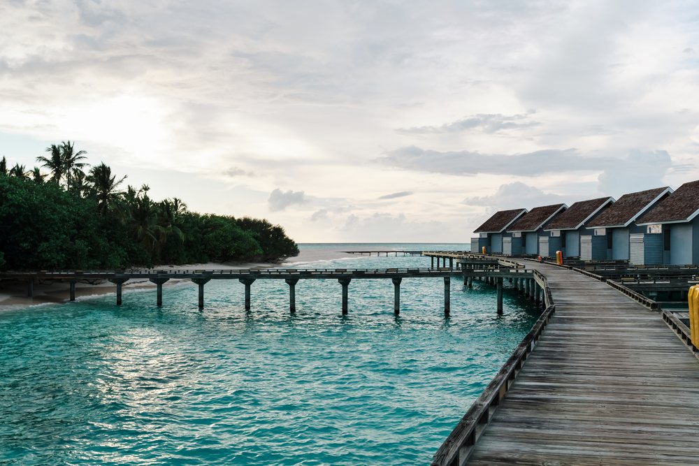 Wooden walkway to overwater bungalows at a tropical resort in a beach
