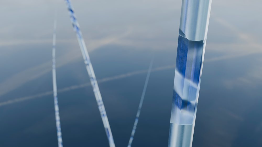 Blue and transparent crystal rods arranged in an artistic abstract form with reflective surfaces in studio lighting.