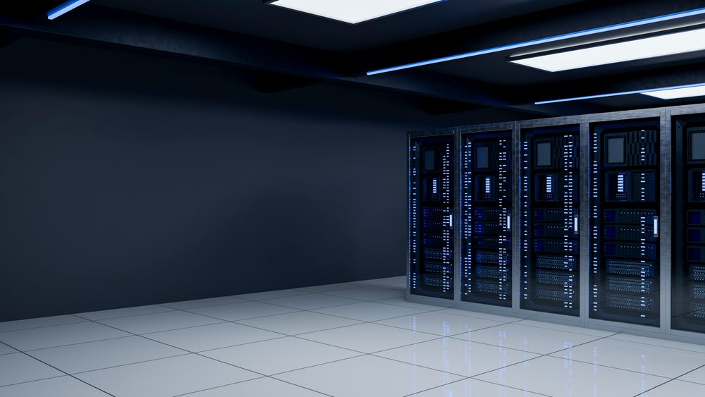 Server racks with illuminated blue status lights stand in a modern indoor data center room with white tiled floors and dark walls.