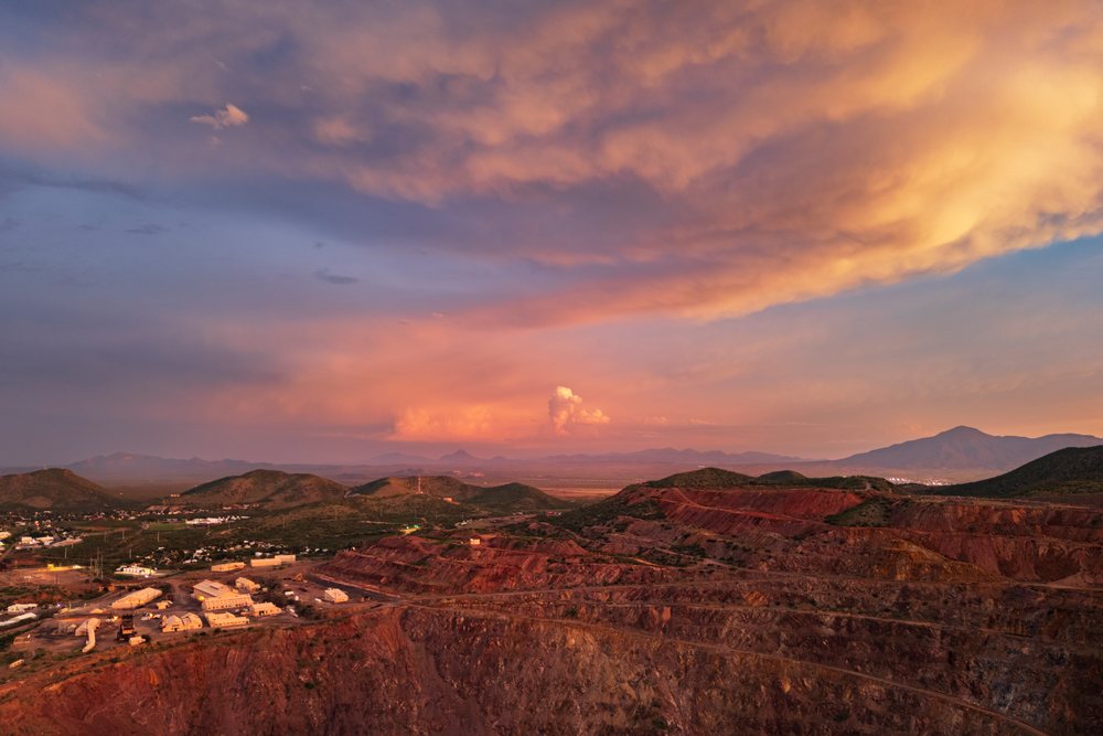 Open pit Copper Mine, at Dusk with adjacent mining buildings and surrounding hills under dramatic clouds, Storm Chasing, Weather, Environment, Bisbee, Arizona, USA.