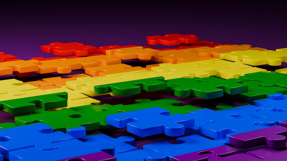 3D digital illustration of colorful interlocking puzzle pieces arranged in rows on a dark surface.