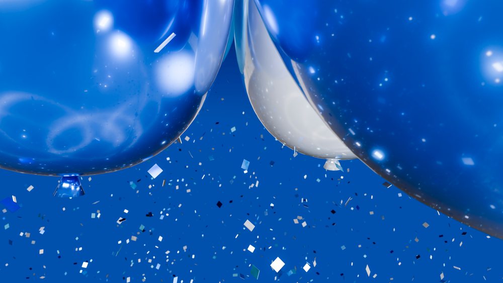 Blue and white balloons with confetti float against a blue background in a festive celebration scene.