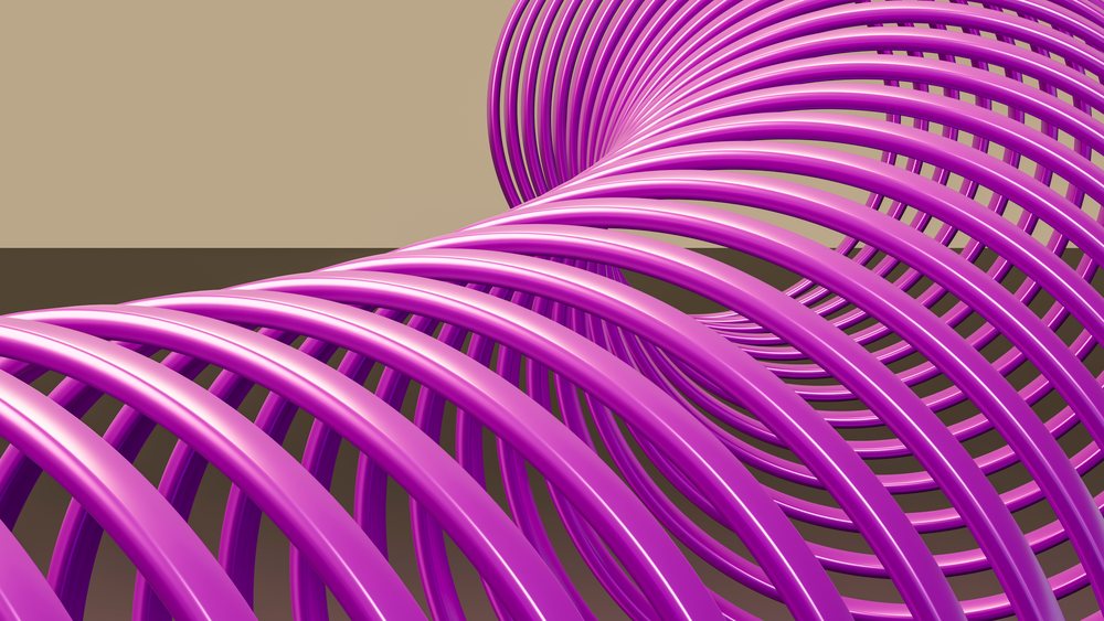 Purple metal spring coil with a symmetrical spiral design on a brown background.