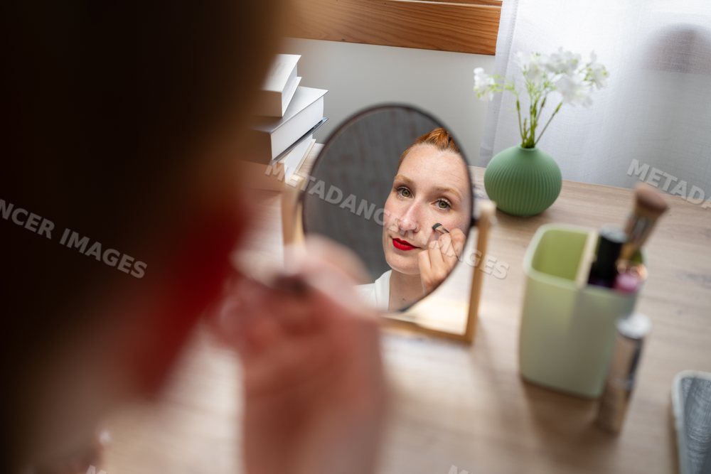White Woman applying makeup at home in Galicia, Spain during working