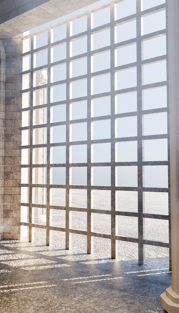 Window grille casting patterned shadows on stone floor interior.