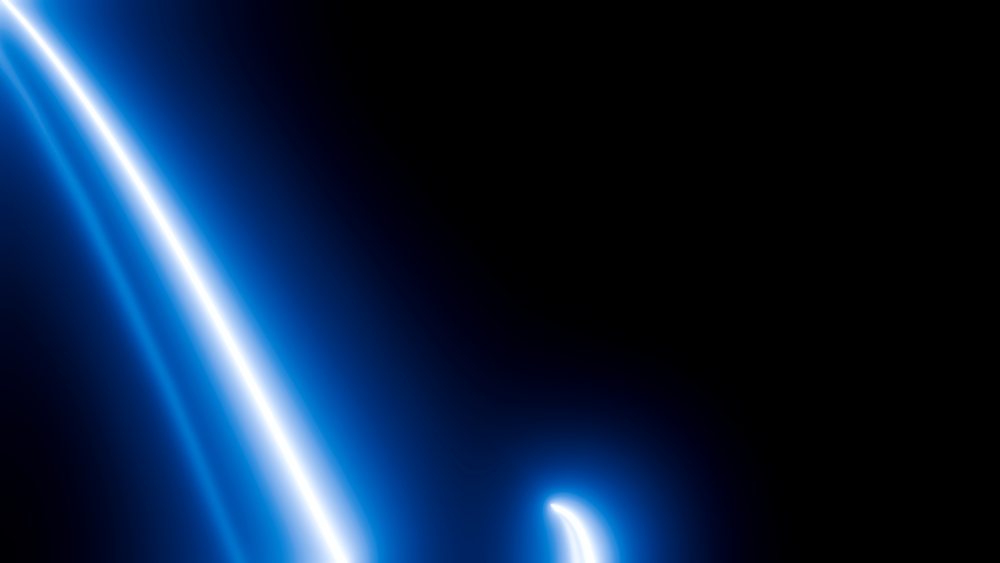 Abstract blue glowing light trails curve dynamically against a dark background in digital art.