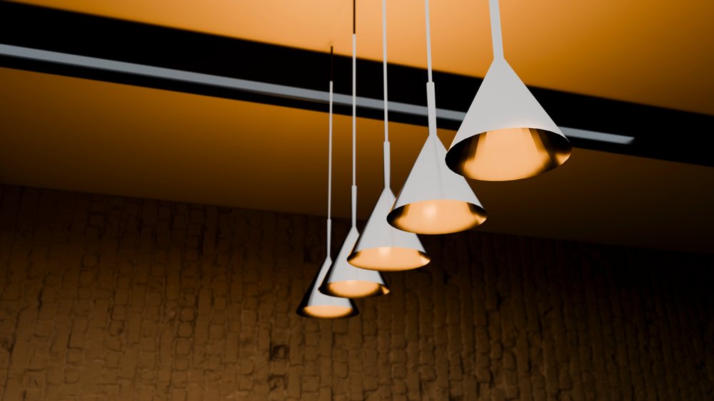 Pendant lights with cone-shaped shades hang from the ceiling in a modern interior setting providing decorative ambient illumination.