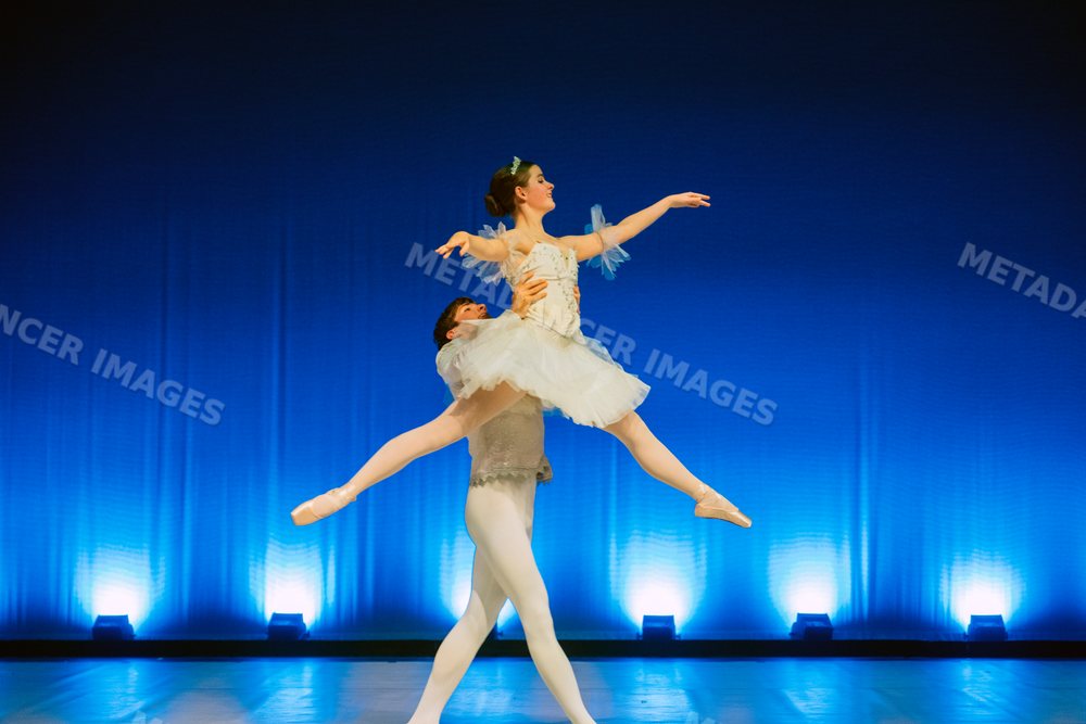 Ballet dancers perform a classical lift on stage