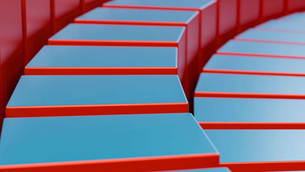 Close-up view of stacked blue rectangular prisms with red edges forming an abstract geometric pattern with highlights and shadows.