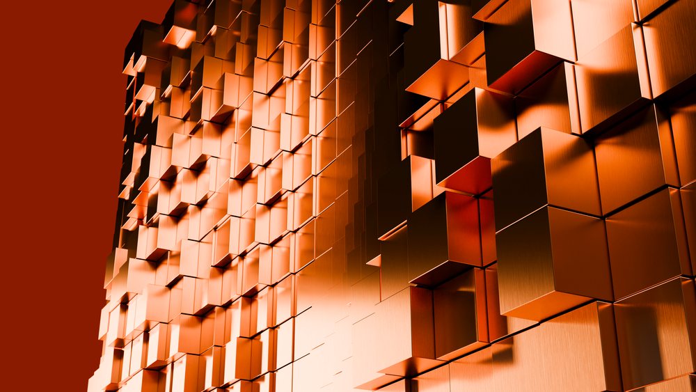 Metallic orange 3D cubes arranged in a repeating abstract geometric pattern with reflective surfaces in a studio setting.