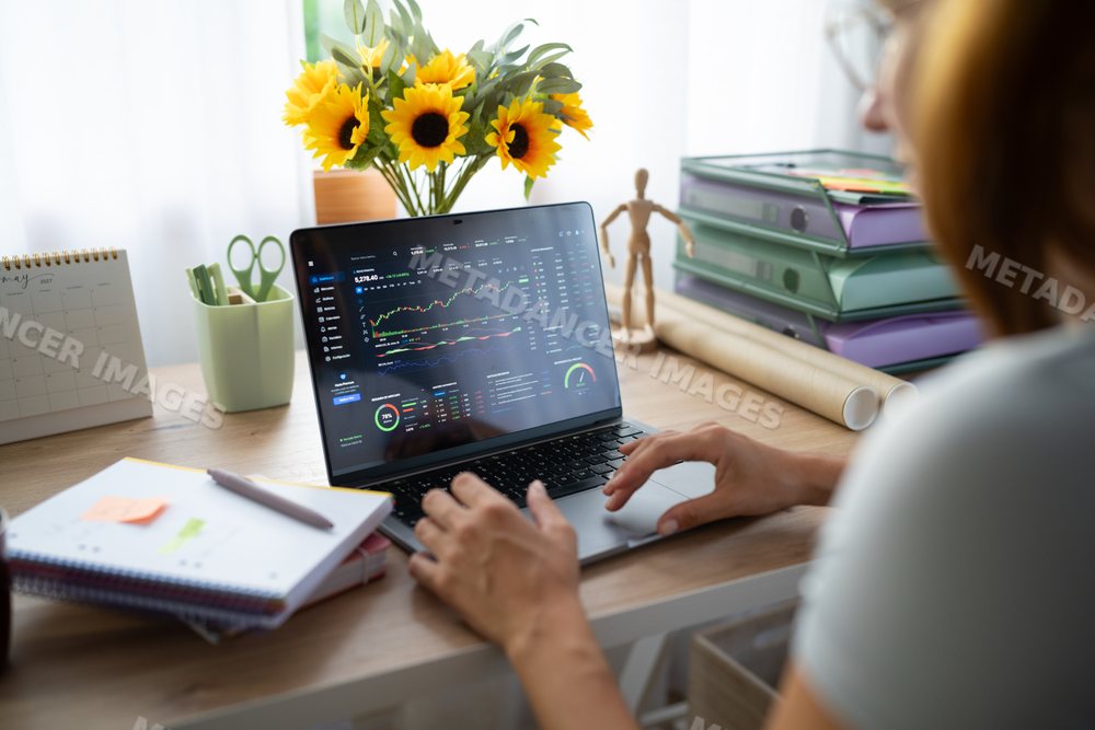 White Person analyzes financial data on laptop in home office in Spain