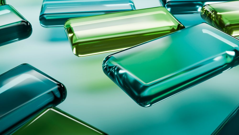 Rectangular blue and green glass blocks arranged in an abstract geometric composition with reflective glossy surfaces.
