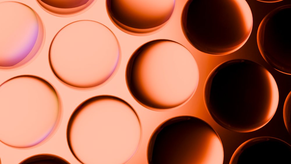 Close-up view of glossy orange circular shapes arranged in a repetitive geometric pattern.