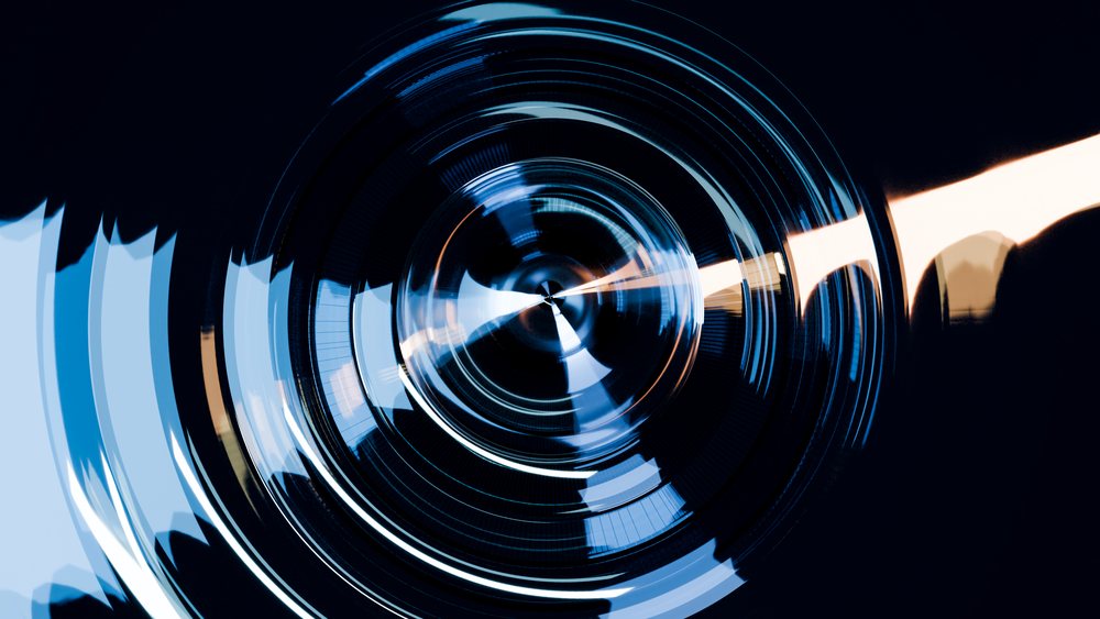 Abstract digital illustration featuring blue and white concentric circular rings with light reflections on a dark background.