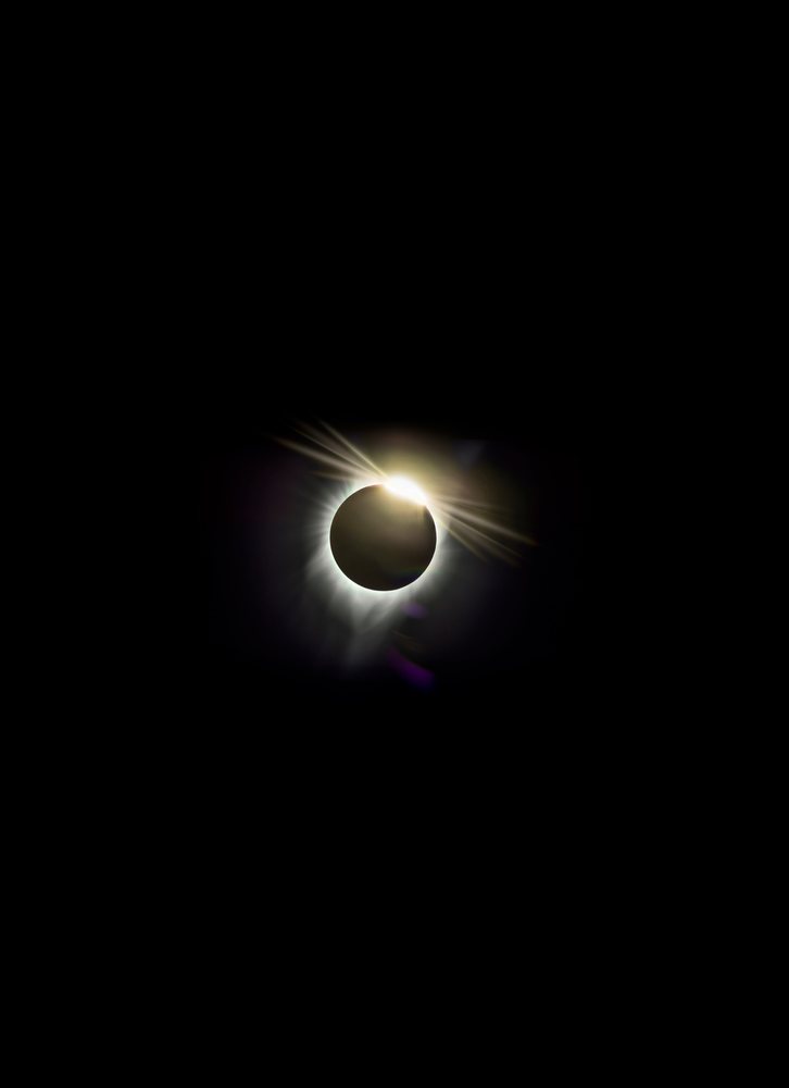 Solar eclipse with diamond ring effect visible in the sky over Los Angeles at night, USA.