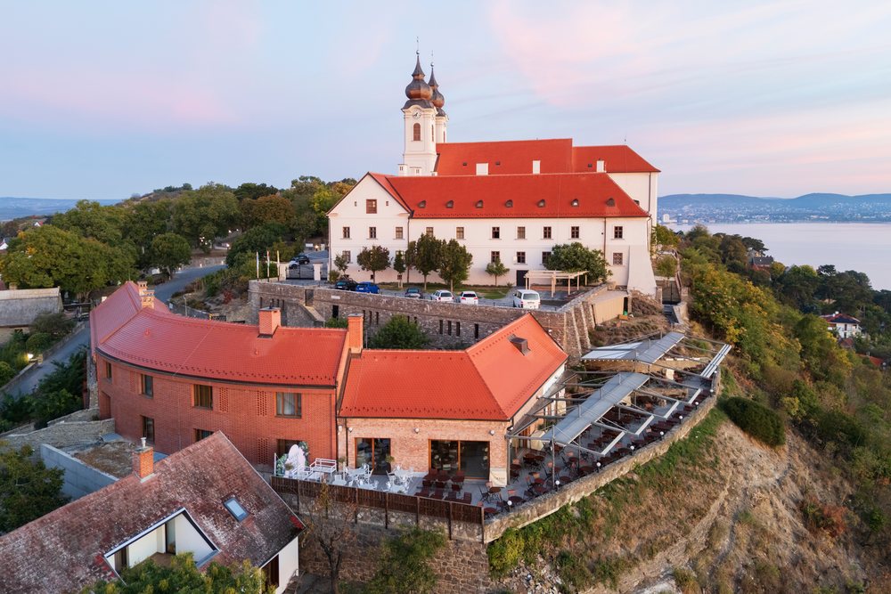 The Benedictine Abbey of Tihany sits atop a hill overlooking Lake Balaton with a terrace and historic architecture, Cityscape, Hungary.