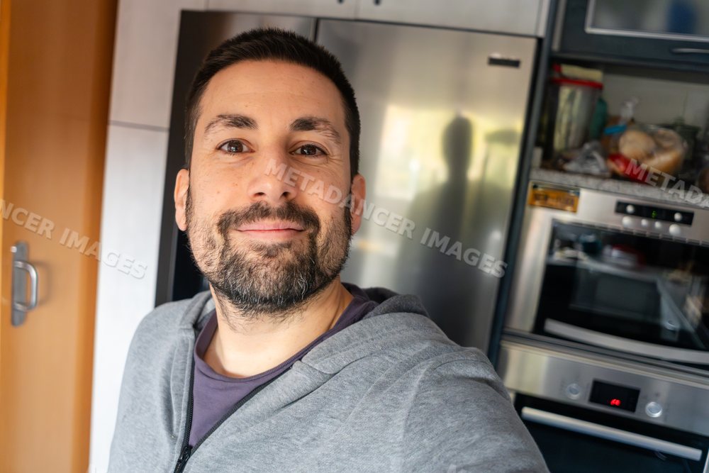 Smiling white man takes a selfie in a modern kitchen