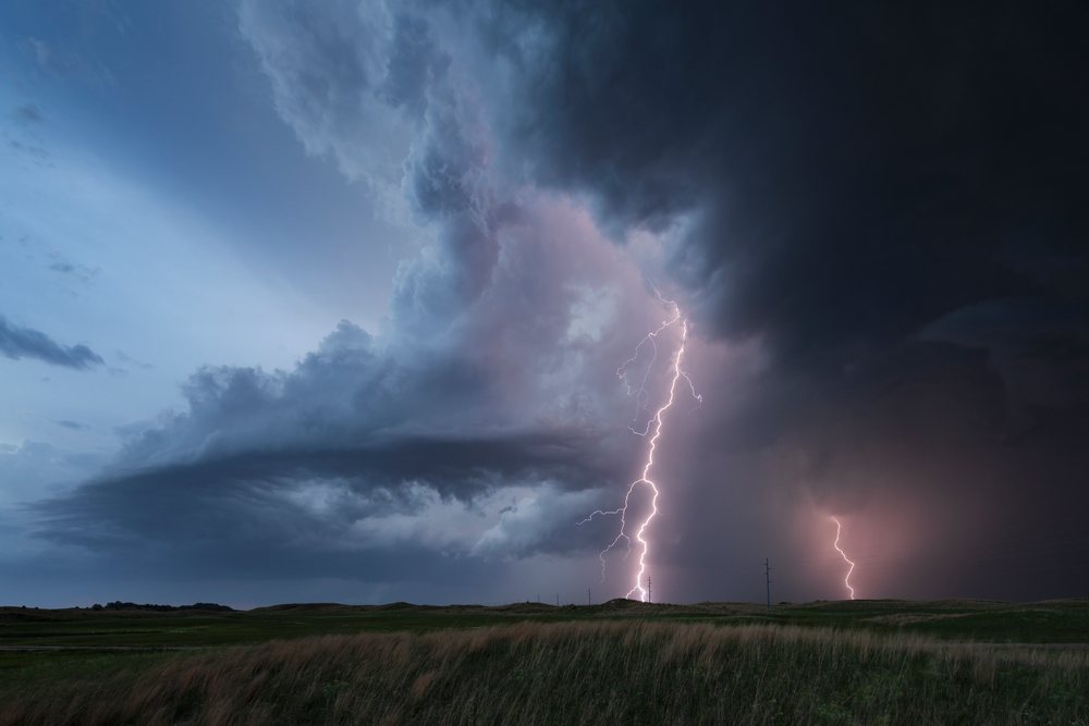Lightning Strike illuminates storm clouds over Nebraska Sandhills grassland near Dunning at blue hour, Storm Chasing, Weather, Environmental Issues, USA.