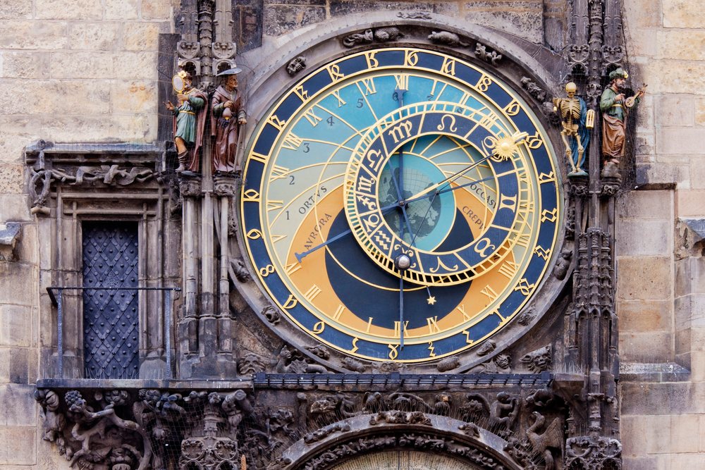 Astronomical clock with sculptures and ornate design on a historical building facade, Prague, Czech Republic.