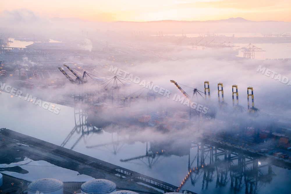 A foggy morning at the container terminal with cranes and ships