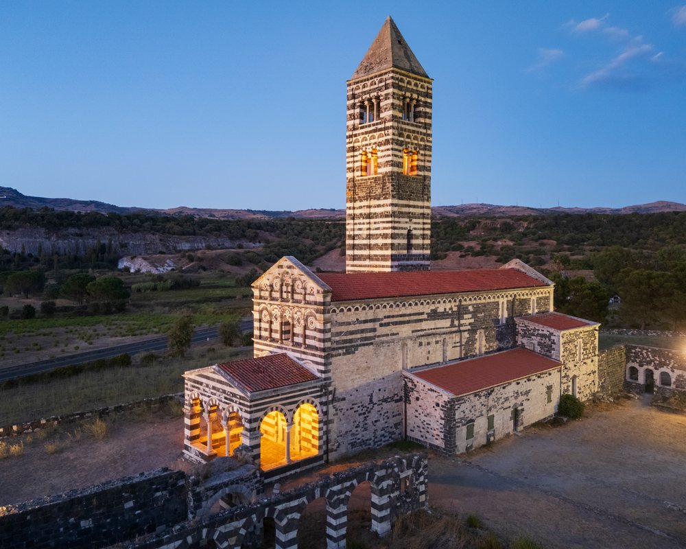 Romanesque church tower with lit interior at dusk in a rural Sardinian landscape in Sardinia, Italy, Travel Images, Sardinia Italy.