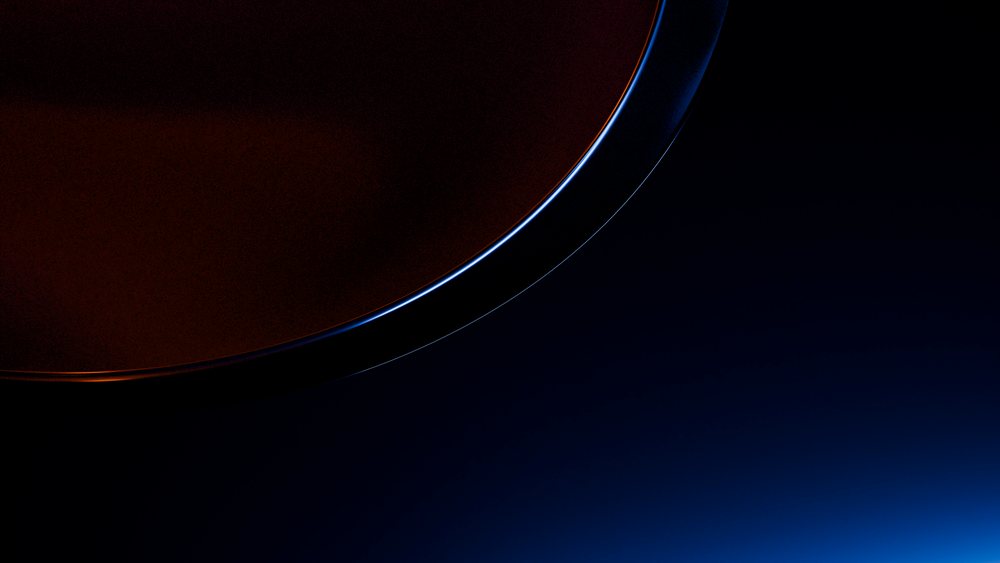 Close-up of a coffee cup filled with dark liquid with blue lighting on the rim against a dark background.