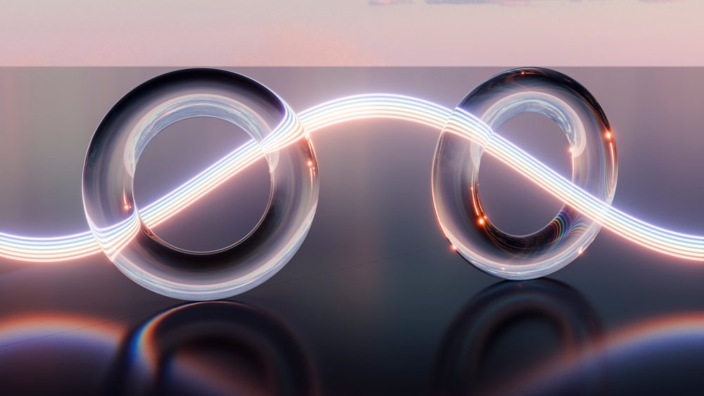 Two glowing glass-like infinity loops with multicolor neon light and reflections on a black surface against a soft pink and purple gradient background in digital 3D art style.
