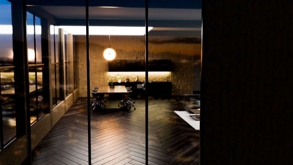 Modern office conference room with a meeting table, office chairs, glass walls, and a hanging spherical pendant light in evening lighting.