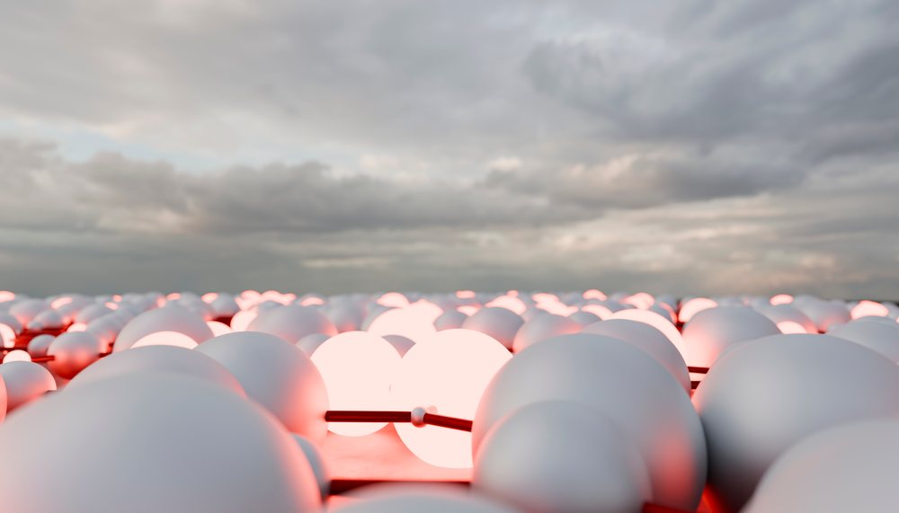 A 3D rendering of glowing connected white spheres with red lighting under a cloudy sky.