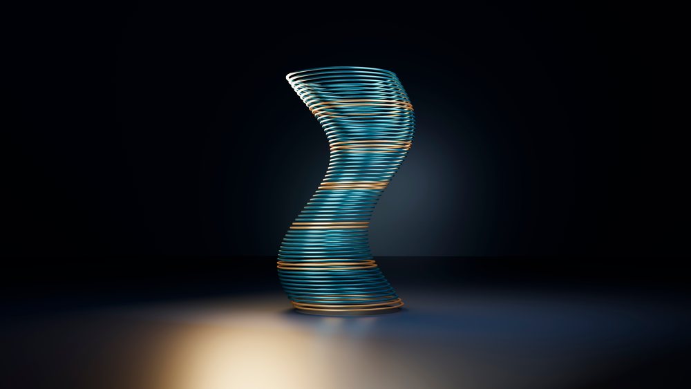 Spiral sculpture with twisting blue and orange spirals illuminated against a dark studio background.