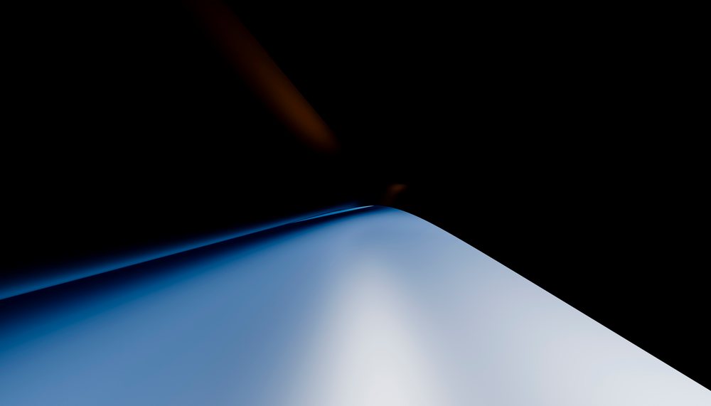 Smooth blue curved shape with gradient lighting on a dark black background.