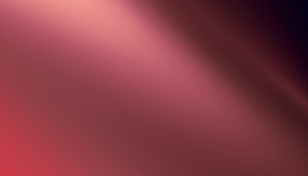 Abstract red gradient background featuring soft blurred light and smooth color transitions.